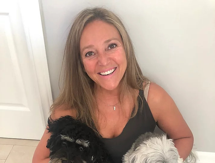 Sandy K sitting on the floor with her dogs